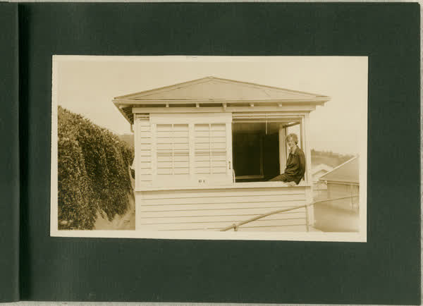 Unidentified woman sitting on a window frame of Sanatorium hut, 1913
