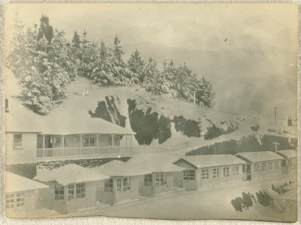 Children's pavilion and top row of women’s huts under snow, 1919