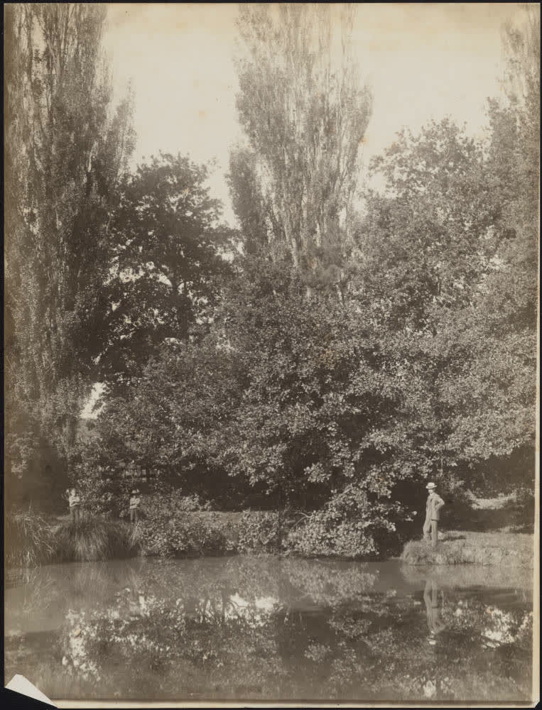 Man and two boys on a riverbank, 1900