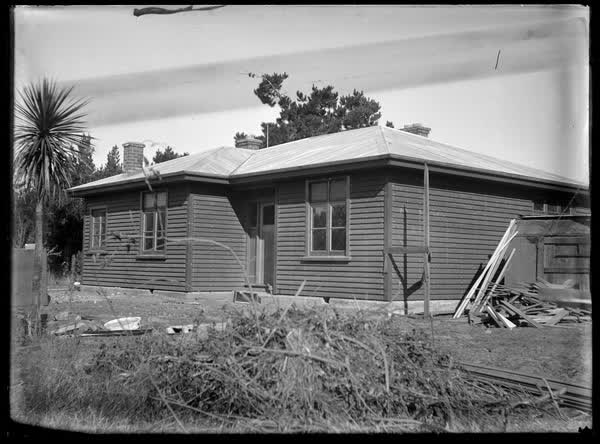 House with wood piles, 1900