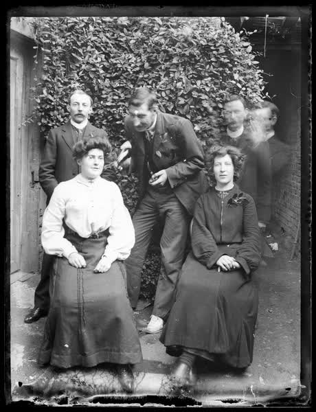 Group portrait in front of a bush, 1910