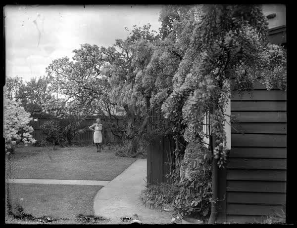 Ruth Sutton standing in a yard, 1950