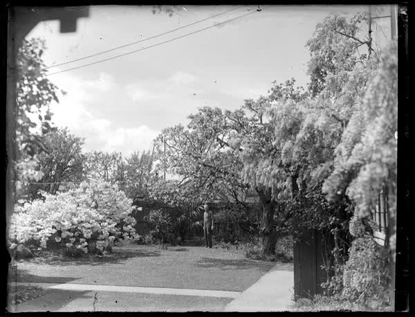 John Sutton standing in a garden, 1940