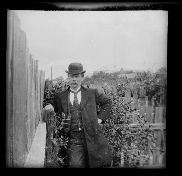 Man leaning on a fence, 1900