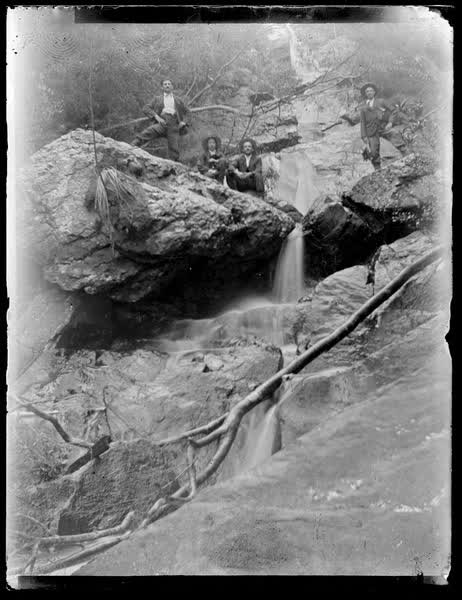 Four men at a waterfall, 1900