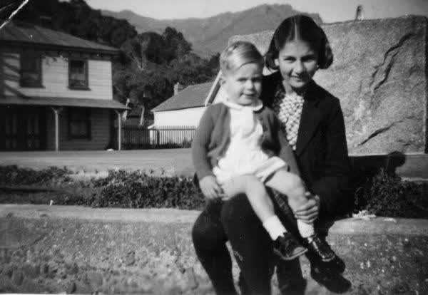 Girl and boy outside a house, 1943
