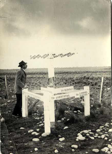 A man next to a sign postJan Shuttleworth collection, 1900