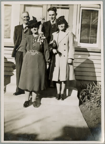 People outside of a weatherboard house, 1920