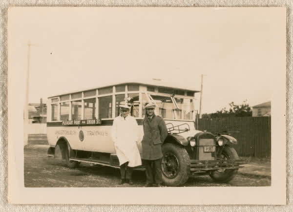 Two men by a bus, 1900