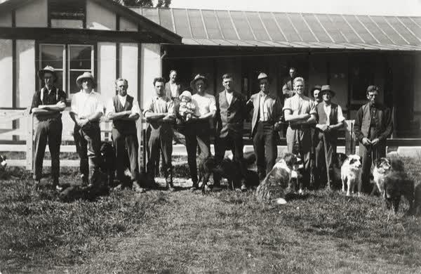 Men outside a house, 1900